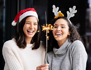 Image showing Women friends, Christmas and sparkle stick with smile, home and celebration of festive holiday. Girl, woman and fireworks with light to celebrate for happiness, vacation or laughing with xmas bonding