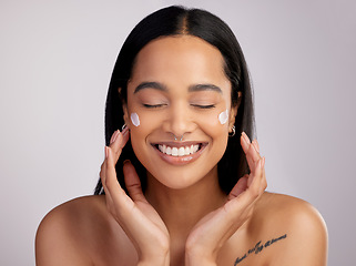 Image showing Happy woman, face and smile with cream for skincare, beauty or cosmetics against a grey studio background. Female person or model smiling for lotion, creme or cosmetic moisturizer or facial treatment