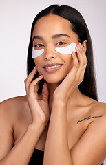 Image showing Happy woman, portrait and eye mask for skincare, collagen or dermatology against a grey studio background. Face of female person or model smiling for beauty cosmetics, patches or facial treatment