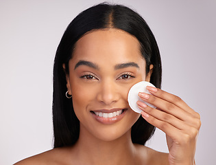 Image showing Happy woman, portrait and cotton pad in skincare or makeup removal against a grey studio background. Face of female person wiping product, cosmetics or remove with swab in cleanse or facial treatment