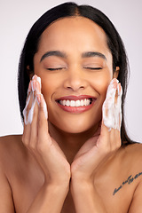 Image showing Happy woman, face and washing for skincare hygiene, cleaning or dermatology against a grey studio background. Female person with smile and soap hands for clean facial treatment, self care or love