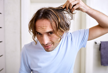 Image showing Healthcare, man checking his hair and grooming in bathroom of his home. Mental health or stress, body care or health wellness treatment and male person checking head for haircare at his house