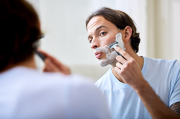 Image showing Man shave face in mirror, foam and beauty with morning routine, cosmetic care and grooming at home. Male person in bathroom, hygiene and shaving cream with razor, hair removal and skincare treatment