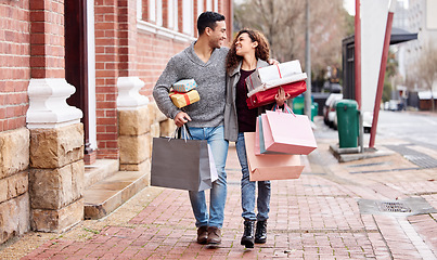 Image showing Happy couple, shopping bags and walking in city with gifts for fashion, clothing or buying outdoors. Man and woman in relationship with smile for customer discount, purchase or payment in urban town