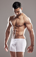 Image showing Man, underwear model and muscle care with strong chest, abs and body with wellness in studio. Bodybuilder, exercise and healthy male person with gray background and muscles from fitness and workout