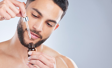 Image showing Mockup, serum and man with skincare, cosmetics and dermatology against a grey studio background. Male person, model and guy with oil, beauty and liquid for face, grooming and routine for smooth skin