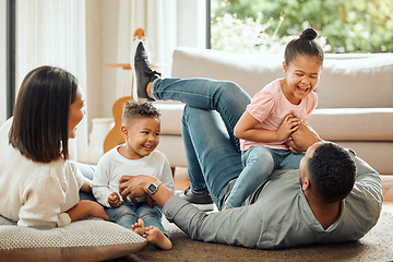 Image showing Happy family, laughing and playing on floor in living room for fun bonding relationship together at home. Father, mother and children enjoying funny play time, laugh or holiday weekend in the house