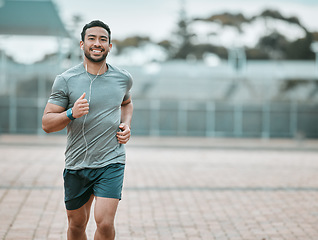 Image showing Sports, portrait and male athlete running with earphones for music, radio or podcast for motivation. Fitness, exercise and man runner in outdoor cardio workout routine for race or marathon training.