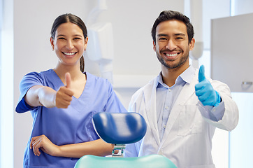 Image showing Dentist team, happy portrait and thumbs up for support, thank you or like emoji. Assistant woman and asian man or healthcare staff for dental care, oral health and wellness with a chair at practice