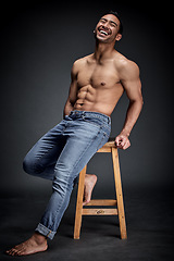 Image showing Smile, muscle and man with fitness, wellness and strong model against a dark studio background. Happy male person, humor and guy laughing, chair and muscular with body builder, sexy and workout goal