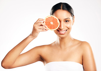 Image showing Happy woman, portrait and grapefruit for vitamin C, diet or skincare against a white studio background. Female person smile with organic fruit in healthy nutrition, natural beauty or facial treatment