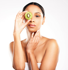 Image showing Woman, portrait and face with kiwi for vitamin C, diet or skincare against a white studio background. Female person or model with natural fruit for healthy nutrition, collagen or facial treatment