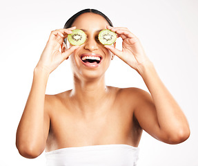 Image showing Happy woman, face and kiwi for vitamin C, skincare or diet against a white studio background. Female person or model with smile and natural fruit for healthy nutrition, collagen or facial treatment