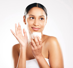 Image showing Woman, face and cream for skincare, beauty or cosmetics against a white studio background. Female person or model with container product, lotion or creme and smile for dermatology or facial treatment