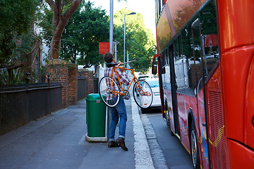 Image showing En route to work. Shot of a man with his bicycle at a bus stop.