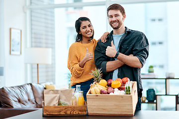 Image showing Good health is the way to go. Shot of a happy young couple showing thumbs up after unpacking their healthy groceries at home.