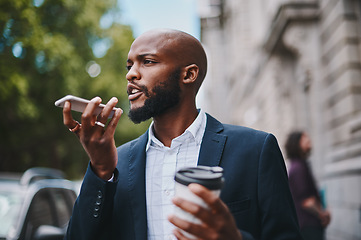 Image showing Youre late for our coffee date. Shot of a businessman using his cellphone while out in the city.