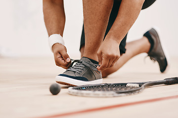 Image showing Get set to get squashed. Cropped shot of a man tying his shoelaces before a game of squash.