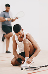 Image showing The countdown to squash awesomeness. Shot of a young man tying his shoelaces before a game of squash.