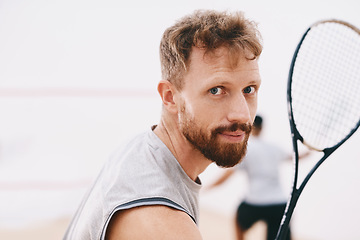 Image showing Have my medal ready for me. Portrait of a young man playing a game of squash with his team mate in the background.