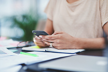 Image showing The digital age demands one to stay connected. Closeup shot of an unrecognisable designer using a cellphone in an office.