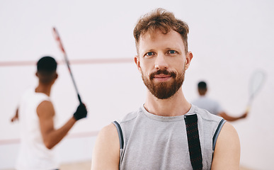 Image showing Bring your best and Ill bring mine. Portrait of a young man playing a game of squash with his team mates in the background.