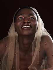 Image showing Things are looking up. Studio shot of an attractive young woman posing in traditional African attire against a black background.