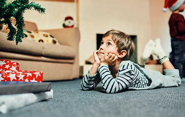 Image showing Dear Santa...I promise Ive been good. Shot of an adorable little boy lying down next to the Christmas tree at home.