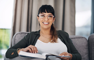 Image showing Being at home is my favourite. Cropped portrait of an attractive young woman sitting alone in her living room and reading a book.