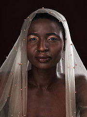 Image showing Whatever youre facing, face it with confidence. Studio portrait of an attractive young woman posing in traditional African attire against a black background.