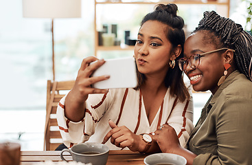 Image showing Just call us the selfie queens. Shot of two young women taking selfies at cafe.