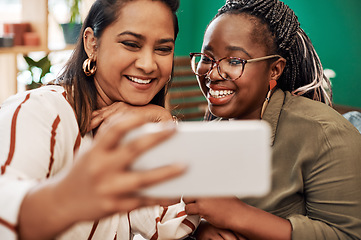 Image showing Live for the moments that make fun memories. Shot of two young women taking selfies at cafe.