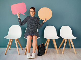 Image showing I speak my mind all day. Studio portrait of an attractive young businesswoman holding up speech bubbles while sitting in line against a grey background.