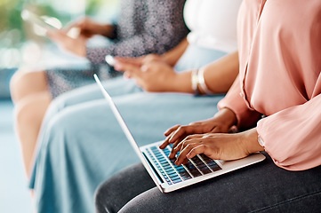 Image showing This is the new way of taking notes. Cropped shot of a group of unrecognizable businesswomen using wireless technology while sitting in line in a modern office.