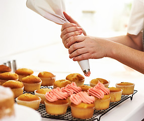 Image showing Add a little magic. Cropped shot of an unrecognizable woman piping icing onto her cupcakes.