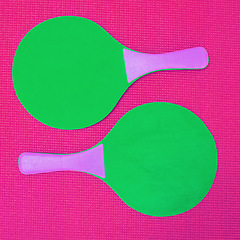 Image showing Simple yet a great game to play. High angle shot of two green table tennis rackets placed on top of a pink background inside of a studio.