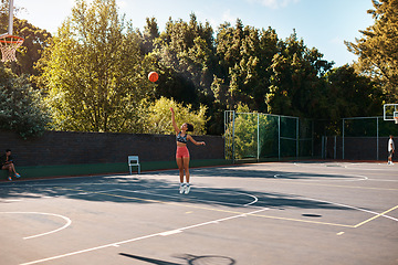 Image showing Its not about how good you are, its how good you want to be. Shot of a sporty young woman throwing a basketball into a net on a sports court.