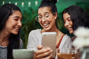 Image showing Sisters bring out our best smiles. Shot of young sisters taking selfies together at a cafe.