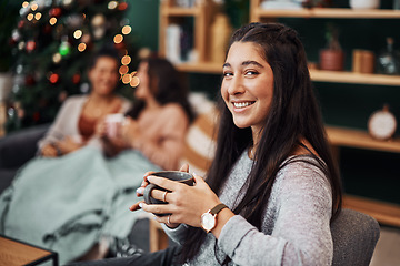 Image showing Hearts come home from Christmas. Shot of a beautiful young woman enjoying a warm beverage with her friends in the background during Christmas at home.