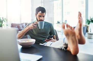 Image showing I have a lot in my feed. Shot of a man using his cellphone while having breakfast at home.