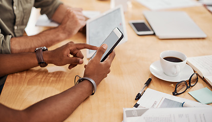 Image showing Connected to business. Closeup shot of a two unrecognisable businessmen using a cellphone and digital tablet in an office.