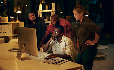 Image showing Im sure we can get this done by the end of the night. Shot of a group of businesspeople looking at something on a computer in an office at night.