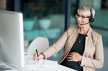 Image showing Providing quality support that customers can appreciate. Shot of a pregnant businesswoman wearing a headset while writing notes in an office.