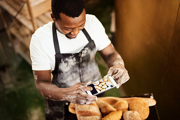 Image showing Do something that youre proud of. Cropped shot of a male baker taking a picture on his cellphone of a selection of freshly baked bread.