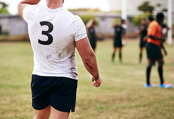 Image showing Lifes short, spend it on a rugby field. Cropped shot of a man playing a game of rugby with his teammates in the background.