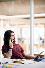 Image showing Do you have any news for me. Shot of a young businessman talking on a cellphone while using a digital tablet in an office.