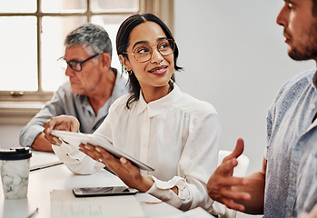 Image showing Teamwork makes a big difference in business. Shot of a group of businesspeople using a digital tablet during a meeting in a modern office.