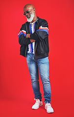 Image showing Clothes never really go out of style. Studio shot of a senior man wearing retro attire while posing against a red background.