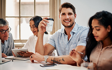 Image showing An indispensable part of a productive team. Portrait of a young businessman having coffee during a meeting with colleagues in a modern office.