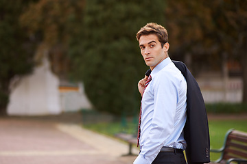 Image showing Success follows wherever he goes. A handsome businessman walking outside with his jacket over his shoulder.